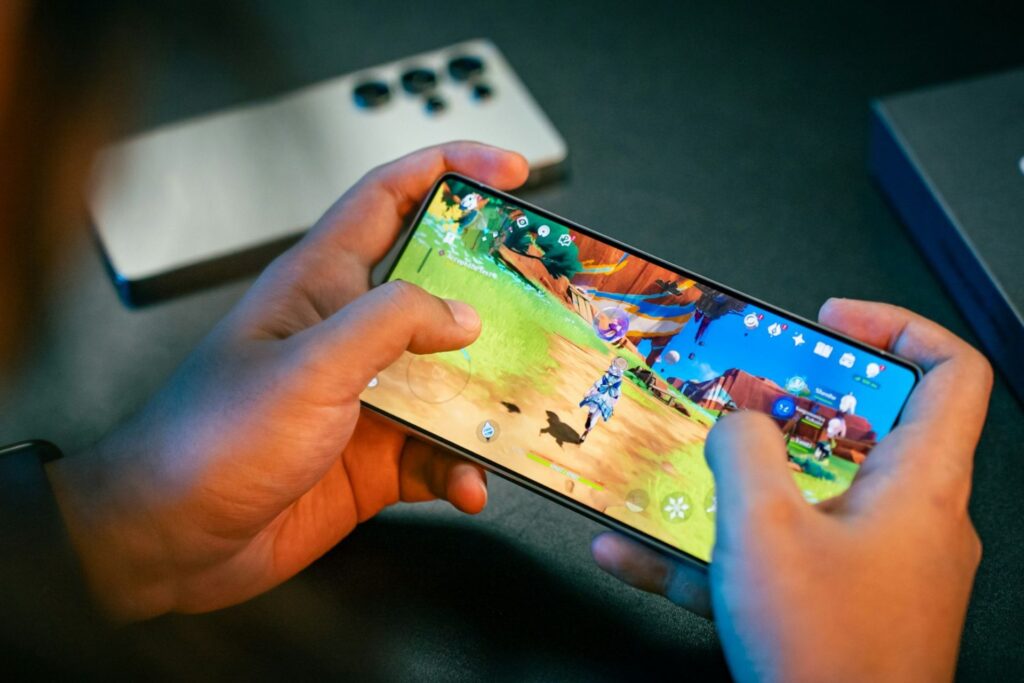 A pair of hands holding a phone, with a game on display