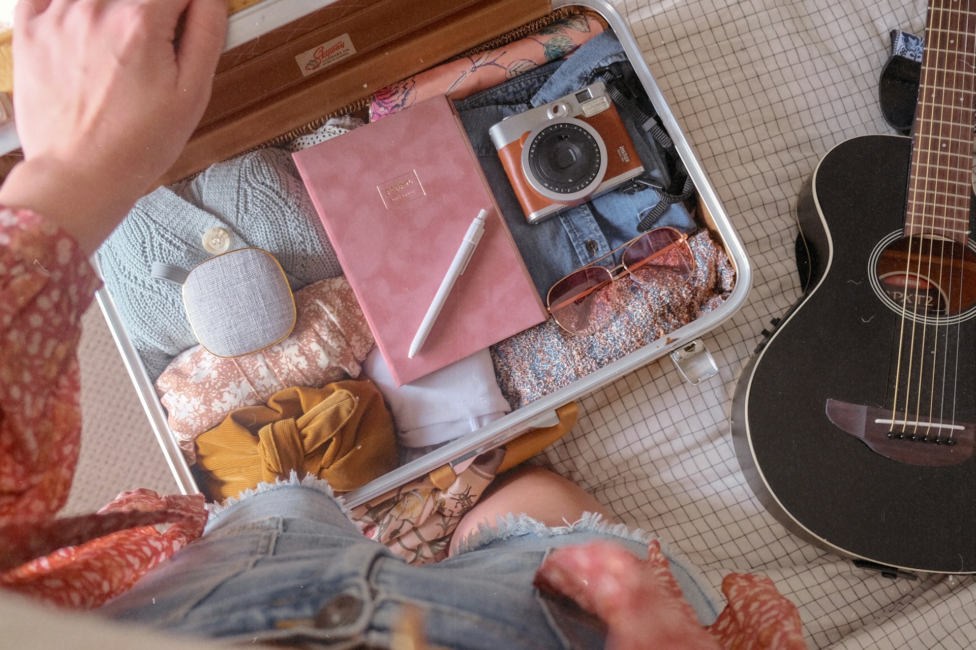 An open suitcase packed with clothes and essentials