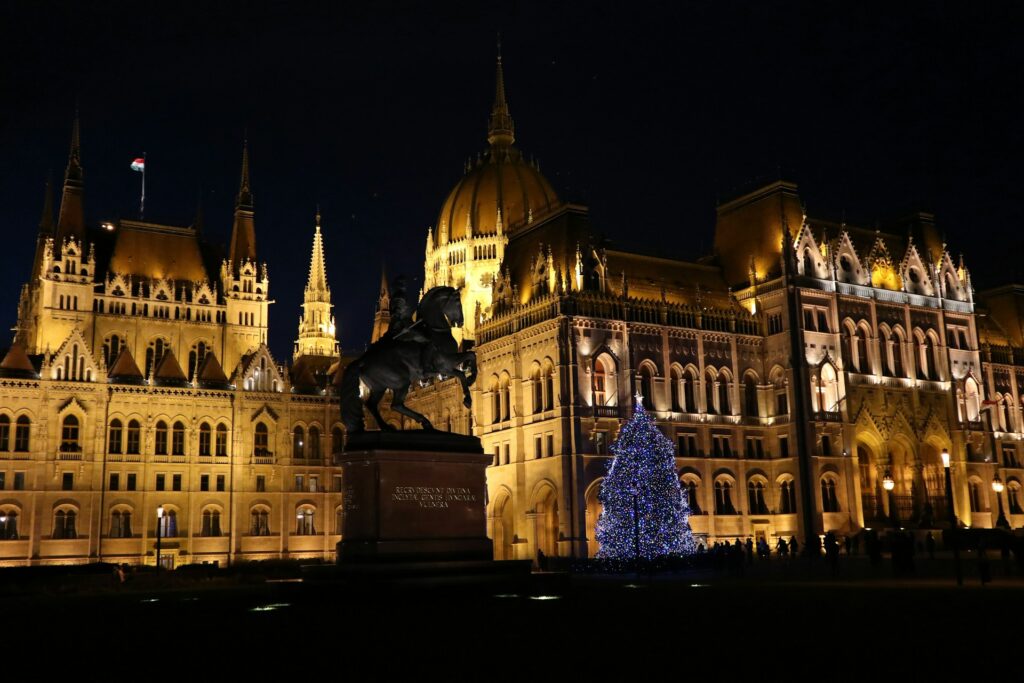 The parliament building in Budapest at night, lit up near Christmas decorations